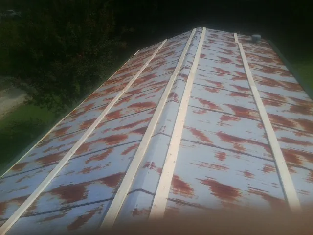 Rusted metal roof panels with new wood purlins before replacement — Storm Damage Roof Repair in Poneto by Roofing Brothers