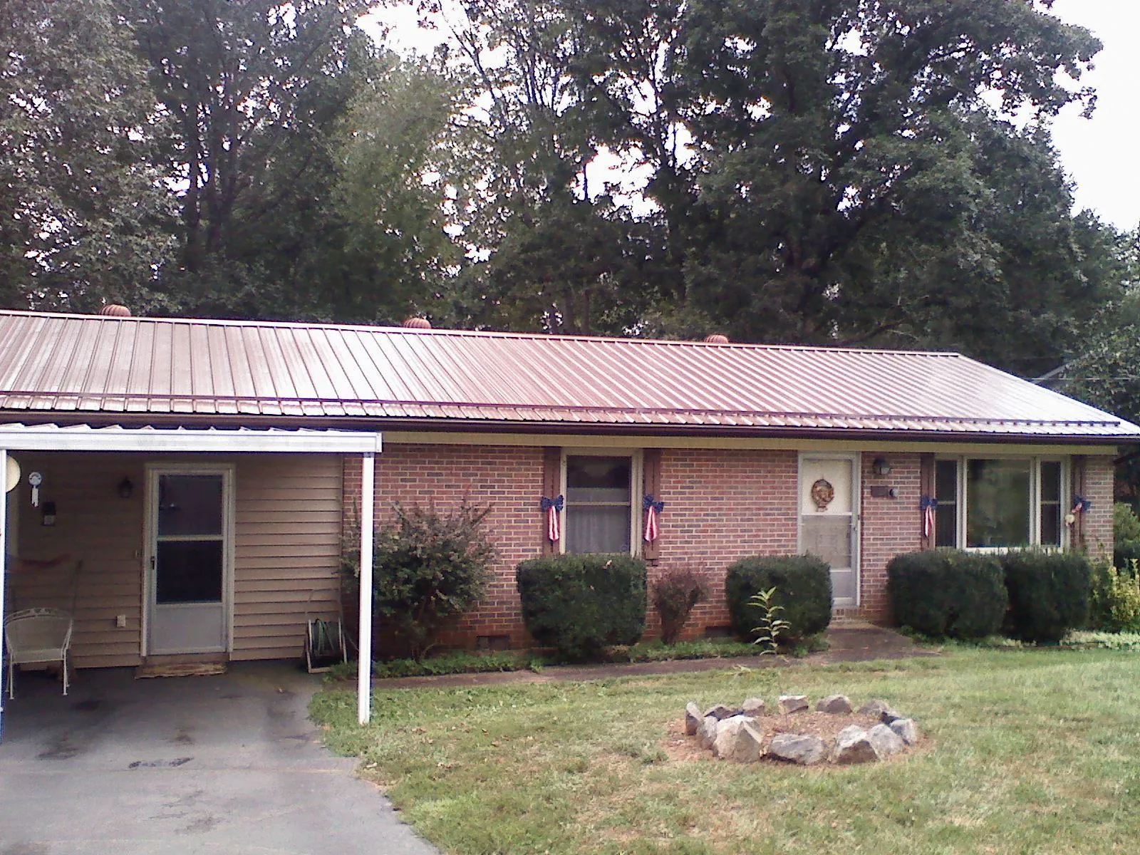 Bronze metal roof and carport on a brick ranch home — Roof Repair work by our crew in Poneto