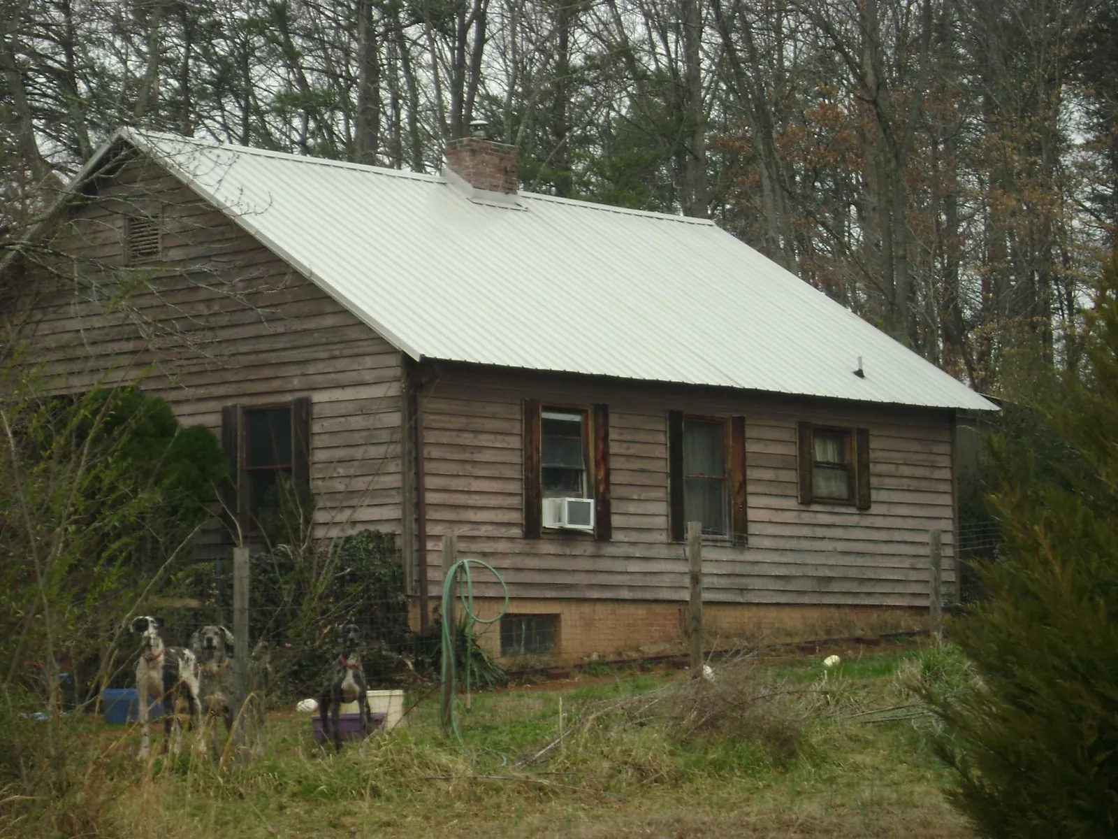 White metal roof on an old wood sided farmhouse, from a Metal Roof Installation job in Poneto